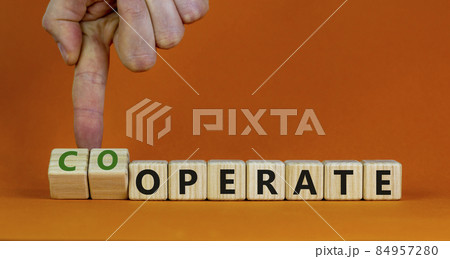 Operate and cooperate symbol. Businessman turns wooden cubes and changes the word operate to cooperate. Beautiful orange table, orange background. Operate, cooperate and business concept. Copy space. 84957280