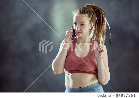 Caucasian woman with braided hair speaks on telephone. Caucasian woman with braided hair speaks on telephone. 84957561