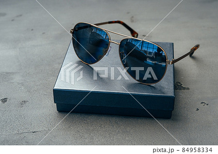New dark aviator glasses on grey concrete background New dark aviator glasses on grey concrete background 84958334