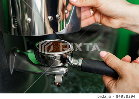 Woman coffee shop worker preparing coffee on professional coffee machine Woman coffee shop worker preparing coffee on professional coffee machine 84958394