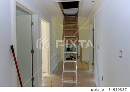 Pull down folding attic ladder stairs in small hallway 84959387