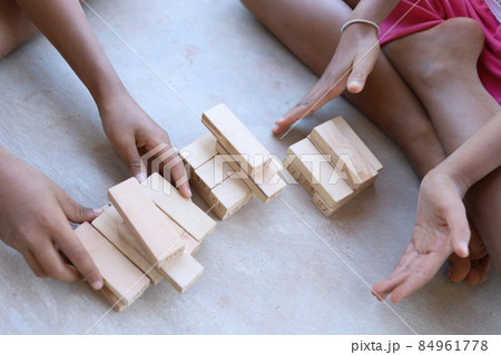 Children playing with wooden blocks on the concrete floor Children playing with wooden blocks on the concrete floor 84961778