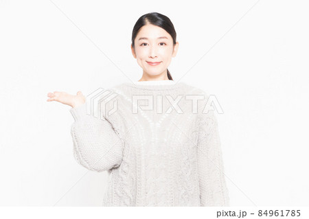 白い背景の前に立って案内をするセーターを着ている主婦 84961785