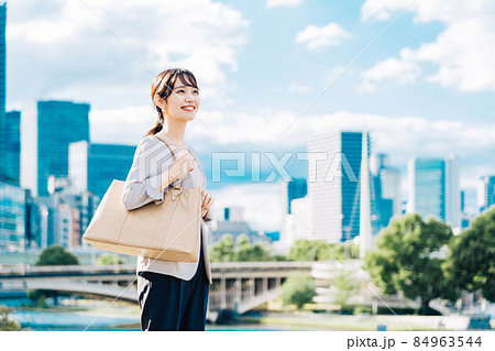青空とビル群を背景にしたビジネスウーマン 84963544