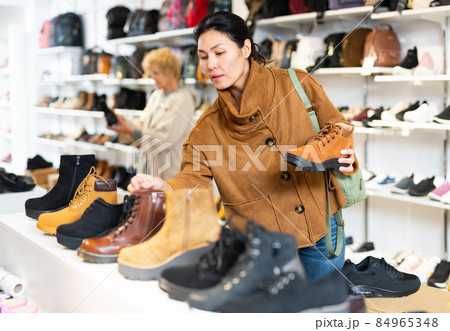 woman selecting new footwear in shoe store 84965348