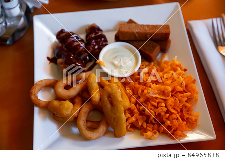 Plate with snack for beer - cheese sticks, chips, croutons and chicken legs Plate with snack for beer - cheese sticks, chips, croutons and chicken legs 84965838