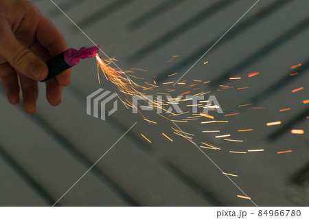 Burning Firecracker with Sparks. Guy Holding a Petard in a Hand Burning Firecracker with Sparks. Guy Holding a Petard in a Hand 84966780