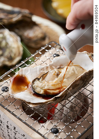 焼き牡蠣に醤油をかける 焼き牡蠣に醤油をかける 84969504