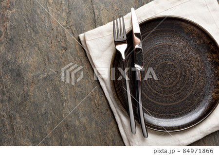 Plate, knife and fork on stone background Plate, knife and fork on stone background 84971866