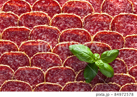 Salami sausage slices with green basil Salami sausage slices with green basil 84972578