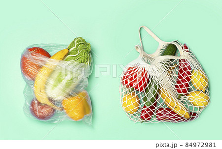 A reusable shopping string bag with vegetables and fruit from the supermarket. Single-use plastic bag ban concept. Zero waste background. High quality photo A reusable shopping string bag with vegetables and fruit from the supermarket. Single-use plastic bag ban concept. Zero waste background. High quality photo 84972981