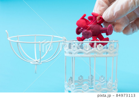 A gloved hand takes the coronavirus out of a metal prison. The concept of biological weapons development. Danger to humanity A gloved hand takes the coronavirus out of a metal prison. The concept of biological weapons development. Danger to humanity 84973113