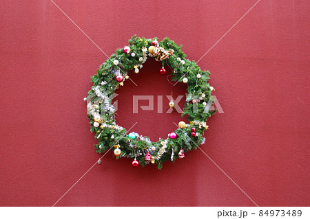赤い壁に飾られたXmasリース 赤い壁に飾られたXmasリース 84973489