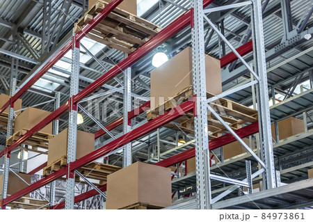 goods are on the shelves of a large warehouse of products 84973861