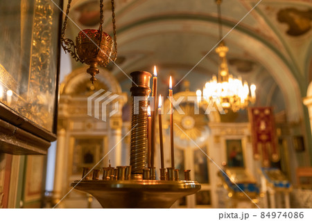 Orthodox Church. Christianity. Festive interior decoration with burning candles and icon in traditional Orthodox Church on Easter Eve or Christmas. Religion faith pray symbol Orthodox Church. Christianity. Festive interior decoration with burning candles and icon in traditional Orthodox Church on Easter Eve or Christmas. Religion faith pray symbol 84974086