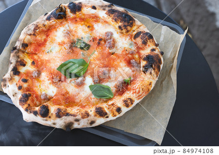 Freshly baked pizza on table in outdoor restaurant 84974108