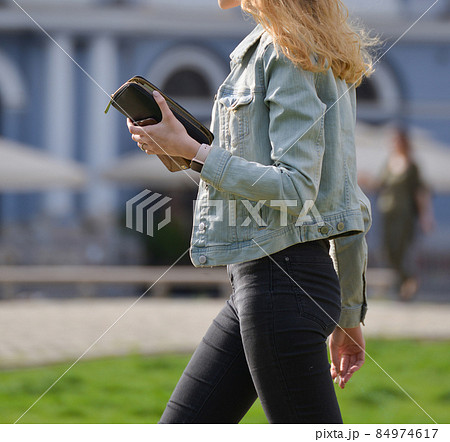 a young girl is smoking on the street 84974617