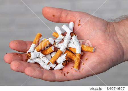 Male hand breaking cigarettes close up quitting habit 84974697