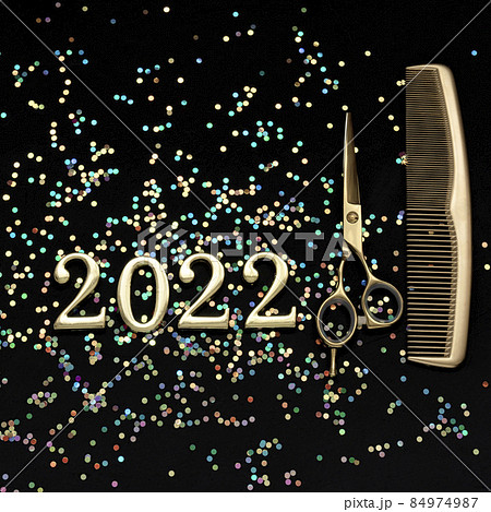 Figures 2022 scissors and comb with confetti on a dark background. Square greeting card of a hairdresser or hair salon. Figures 2022 scissors and comb with confetti on a dark background. Square greeting card of a hairdresser or hair salon. 84974987