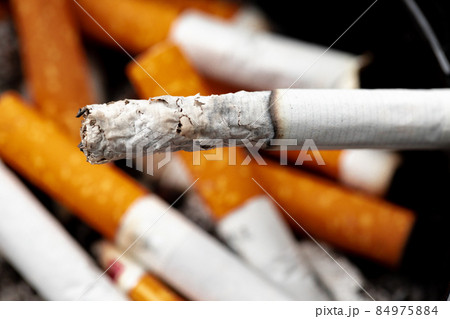 Burning cigarette in a black ash tray Burning cigarette in a black ash tray 84975884