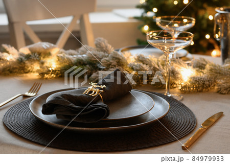 Christmas festive table setting, gold decorate and champagne. Family holiday dinner or New Year party. Christmas festive table setting, gold decorate and champagne. Family holiday dinner or New Year party. 84979933