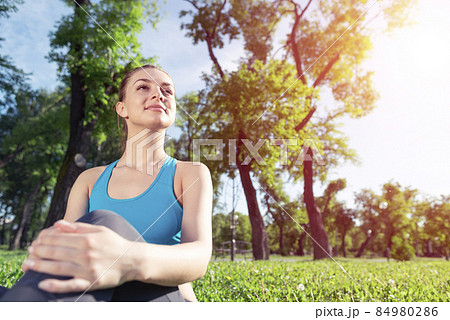 Beautiful smiling girl in sportswear relax in park Beautiful smiling girl in sportswear relax in park 84980286