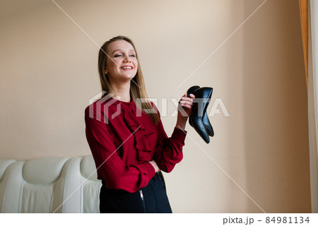 Beautiful woman at home with shoes in her hands 84981134