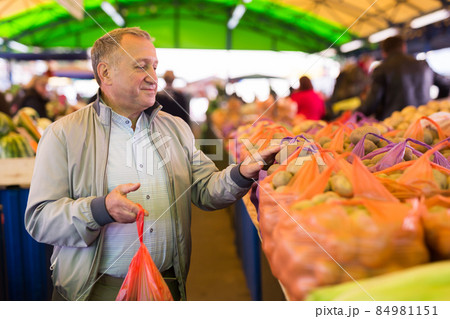 Man buying potatoes in market 84981151
