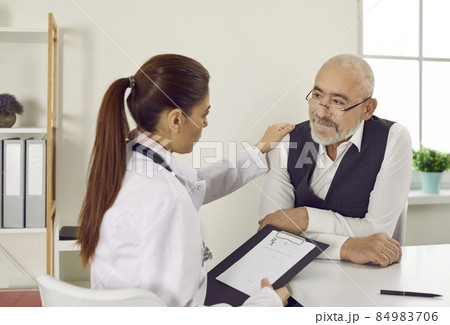 Caring young woman doctor comfort support mature male patient at consultation in clinic. Attentive female nurse touch shoulder caress senior man in hospital. Good medical service. Health insurance. Caring young woman doctor comfort support mature male patient at consultation in clinic. Attentive female nurse touch shoulder caress senior man in hospital. Good medical service. Health insurance. 84983706