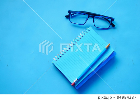 high angle view of blue color notepad with pencil on blue desk  84984237