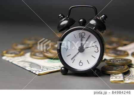 alarm clock , coins and cash on dark background  84984246