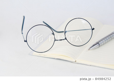 notepad, eyeglass and a pencil on wooden table  84984252