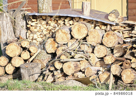 Pile of firewood into the distance the walls of the house Pile of firewood into the distance the walls of the house 84986018