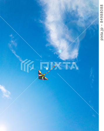 Kite blue sky. Colorful high flying toy. Air kite fly on wind clouds. Rainbow kite in summer background. Concept of dreams, freedom, childhood. 84988088