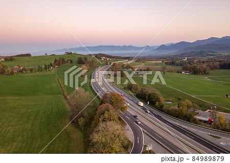 Top down aerial view of freeway interstate road with moving traffic cars in rural area. Top down aerial view of freeway interstate road with moving traffic cars in rural area. 84989879
