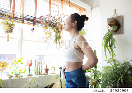 部屋で体を鍛えるかわいい女性 84989968