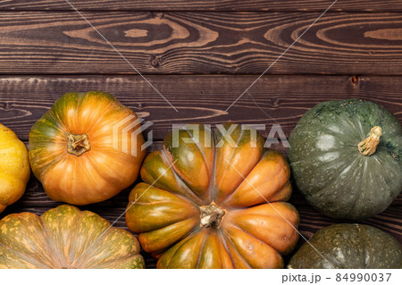 Assortment of small pumpkins on wooden background 84990037