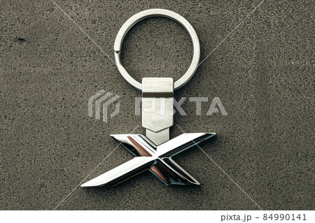 Metal letter X car key on dark concrete background 84990141