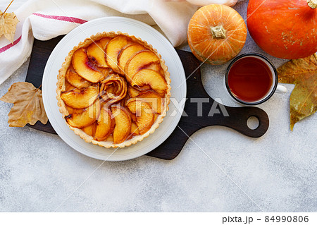 Apple tart pie on table with pumpkin and dry leaves 84990806