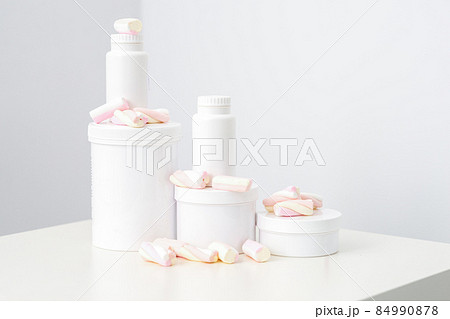 Cosmetic skincare packaging. Beauty product on white background. White jars with marshmallows on the white table. 84990878
