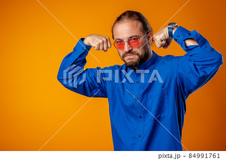 Bearded man in shirt showing bicep and looking at camera 84991761
