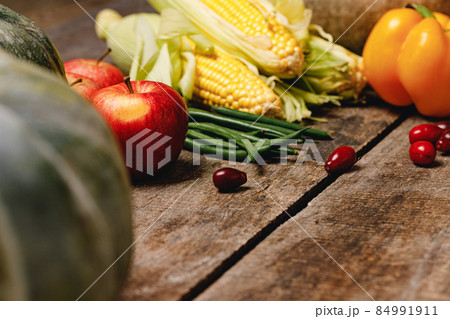Corn cobs, apples, and pepper on wooden table Corn cobs, apples, and pepper on wooden table 84991911