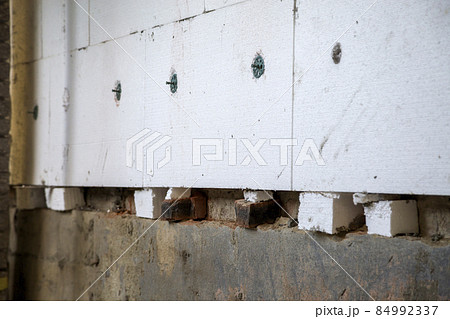 Insulation work of house walls with styrofoam sheets. 84992337