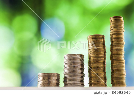 Growing coins stacks with green and blue sparkling bokeh background. Financial growth, saving money, business finance wealth and success concept. 84992649