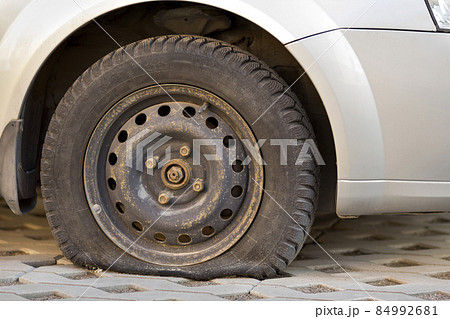 Flat tire of car on pavement. Side view outdoors of vehicle close up. Transportation problem, accident and insurance concept. 84992681