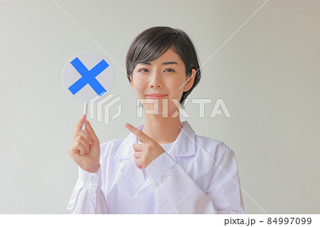 Xのプレートを笑顔で指さす白衣女性2 Xのプレートを笑顔で指さす白衣女性2 84997099