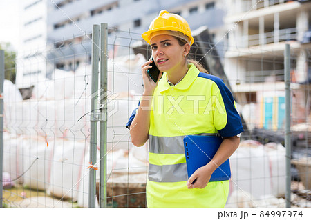Young woman working as a process engineer talkes on a mobile phone 84997974