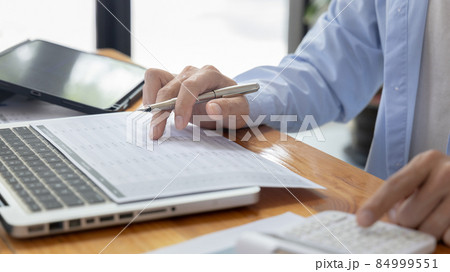Businessman presses a calculator to calculate earnings and analyze company earnings in his private office, Information in finance and accounting, Company performance and revenue. Businessman presses a calculator to calculate earnings and analyze company earnings in his private office, Information in finance and accounting, Company performance and revenue. 84999551