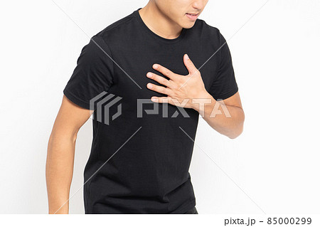 白い背景の前に立って胸に手を当てる黒いTシャツを着ている男性 白い背景の前に立って胸に手を当てる黒いTシャツを着ている男性 85000299