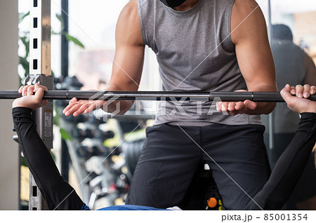 筋トレを教えるトレーナーとプライベートレッスンをバーベルの受ける人 筋トレを教えるトレーナーとプライベートレッスンをバーベルの受ける人 85001354